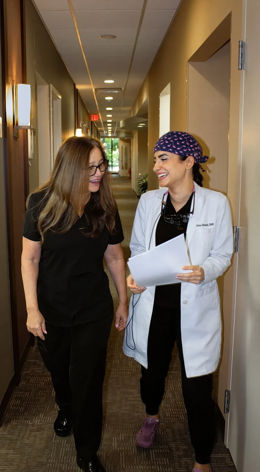Dentists walking in hallway reviewing charts